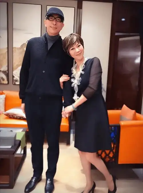 黑色长裙,显得才40多岁,她小鸟依人般,笑意盈盈地站在第二任丈夫旁边