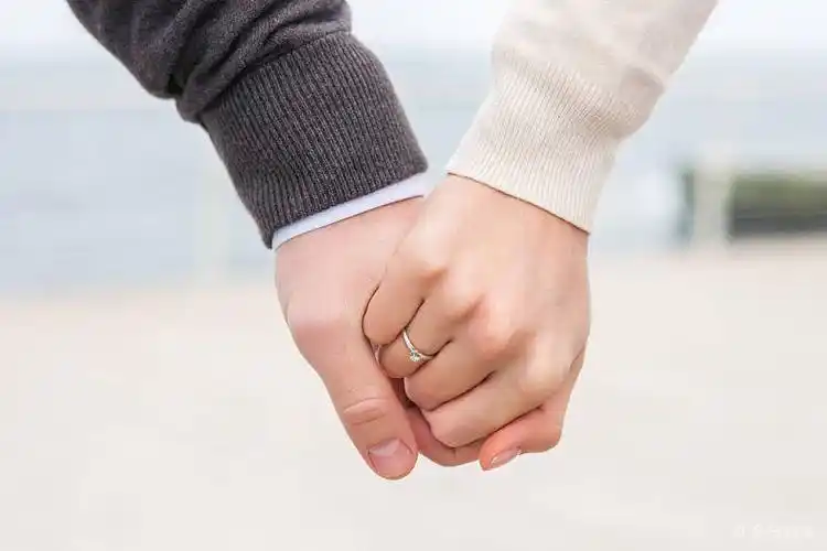 年轻一对牵手手婚戒亲密特写展示男青年