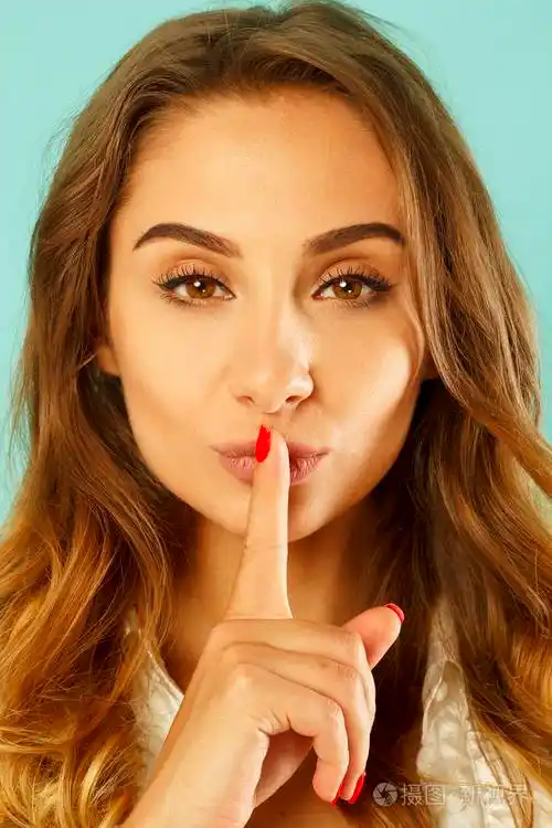 年轻漂亮的女人说嘘手势蓝色背景