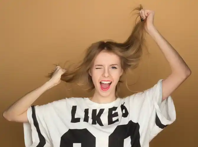 一个小女孩在玩头发一件 t 恤