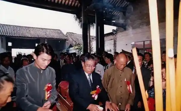 刘德华手持香火,虔诚地鞠躬致敬.