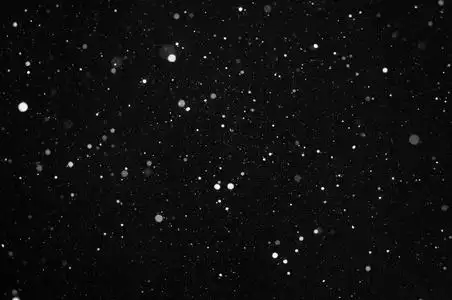 在黑色背景上漫天飞舞的雪花照片