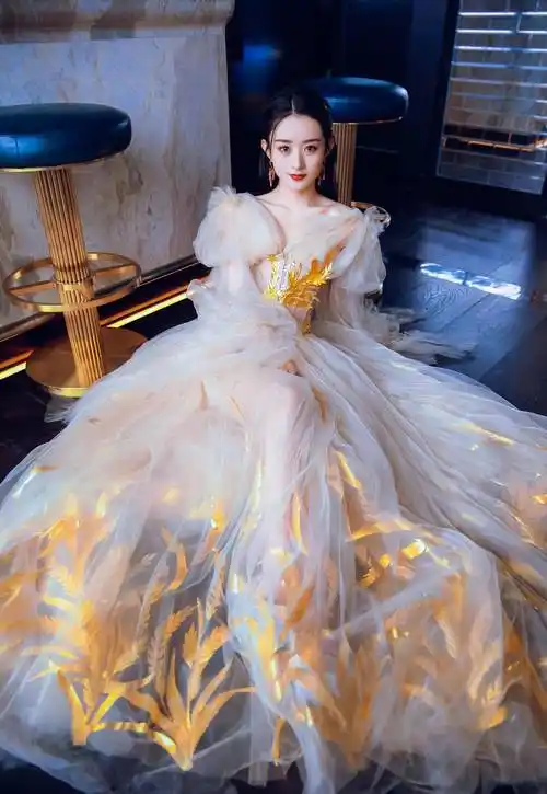 "优雅如画,赵丽颖身穿白色长裙,黑发披肩,头戴金色发卡,坐在地上,宛如