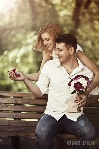 爱与婚礼概念.坐在公园的幸福小两口