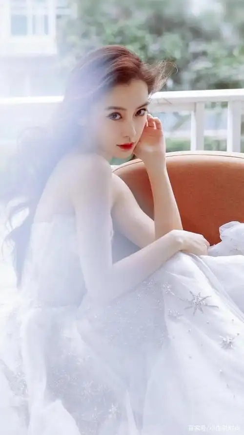 杨颖身穿一袭白色婚纱裙,展现魔鬼的身材,十分迷人