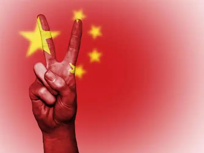 爱国中国红色国旗下一只摆着手势的手背景图片