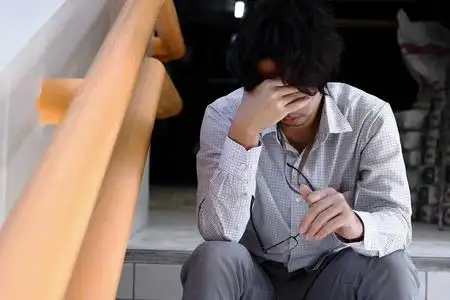 失意的年轻亚洲男人抚摸着头, 感到失望或疲惫.失业的生意人概念照片