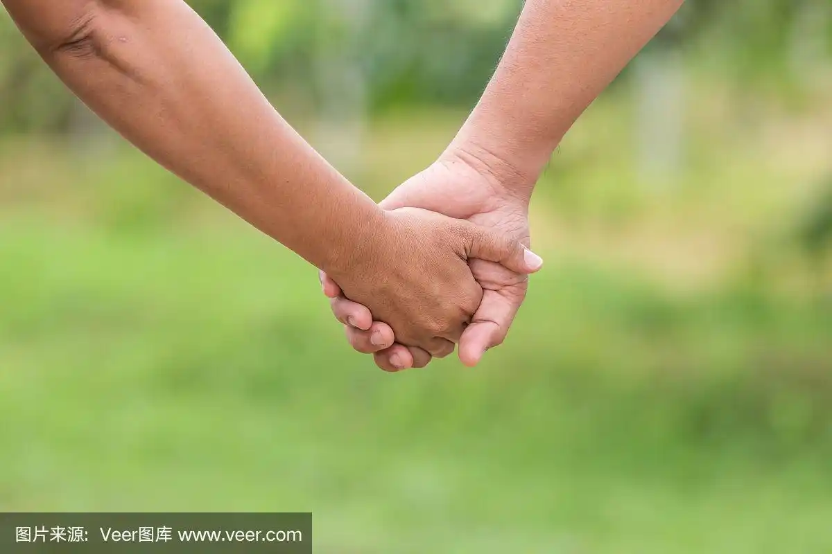 两只手握在一起.帮助或支持概念.在绿色模糊