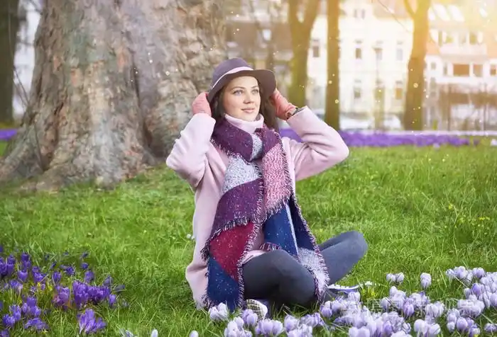 美丽幸福的女人在春天的草地上的帽子