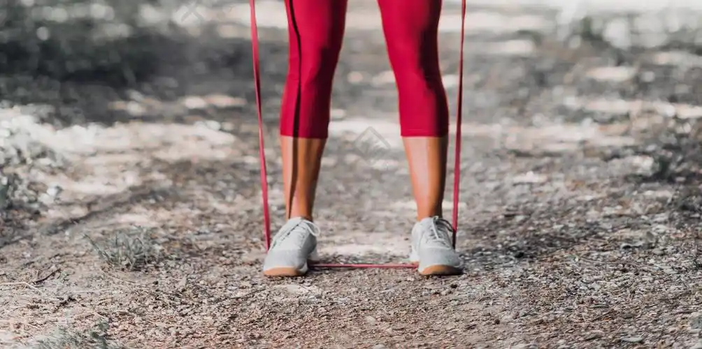 户外运动在公园里用松紧带锻炼的女运动员