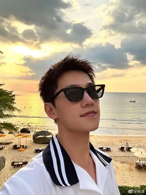 图中杨洋戴棒球帽,身穿灰黑色系休闲服双手插兜,背影难掩帅气,画面中