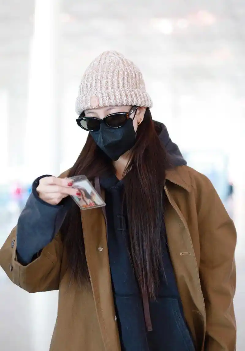 宋妍霏机场街拍,棕褐色风衣 连帽卫衣 毛线帽这样穿让时髦毫不费力