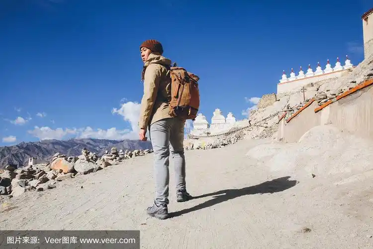 男性亚洲旅行者在沙丘上爬山