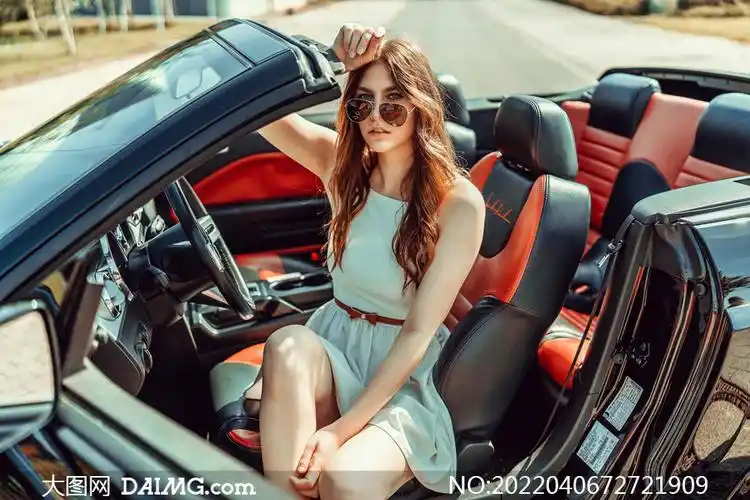 敞篷跑车里的长发墨镜美女摄影图片