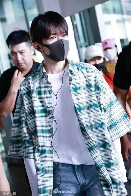 易烊千玺戴耳机酷帅现身 装扮清新包裹严实帅值不减