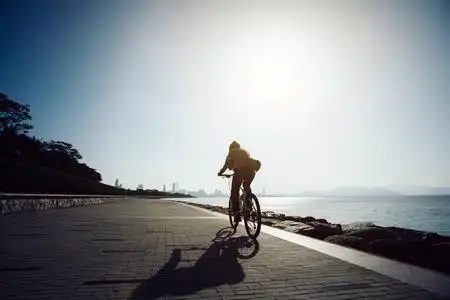 自行车在日出海岸骑车骑山地自行车在日出海岸骑摩托车的人穿着防护服