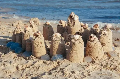 在一个清楚的夏日建造了沙子城堡在海洋的海滩的一个清楚的晴朗的夏天