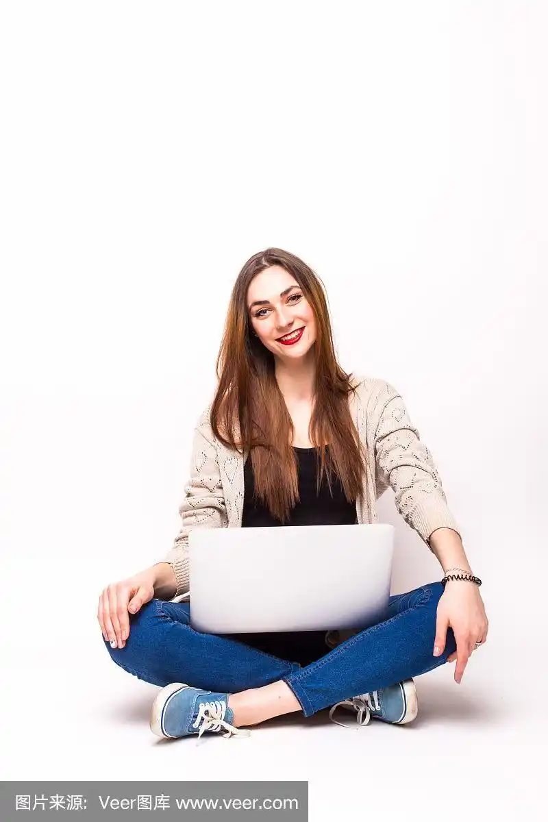 快乐的女人坐着腿,用着笔记本电脑