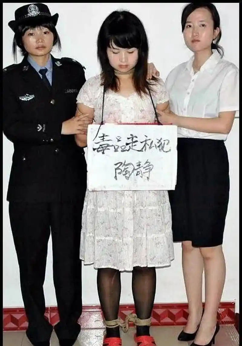 这张图片拍摄的是一个女毒贩,被绑上了法绳,即将押