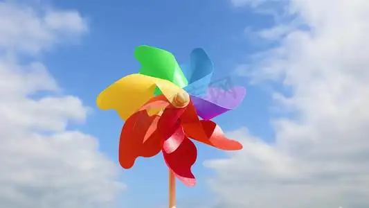 夏天蓝天白云下转动的彩色风车