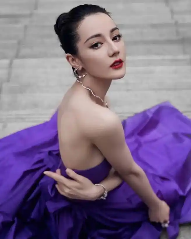迪丽热巴工作室晒出一组写真美照当天热巴身穿一袭紫色长裙在户外拍摄