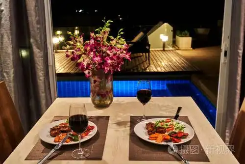在别墅俯瞰游泳池的浪漫晚餐