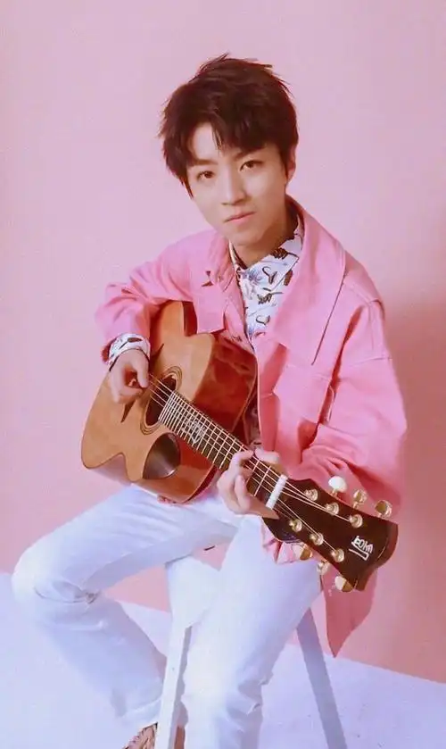 中的王俊凯穿着一件粉色外套,下面配着一条白色休闲裤