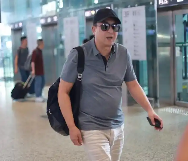 张嘉译脚踩人字拖现身机场,大肚腩格外抢镜,左腿红绳本命年?