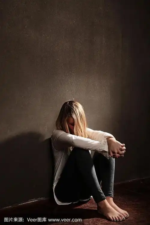 悲伤的少年在黑暗的房间里低头