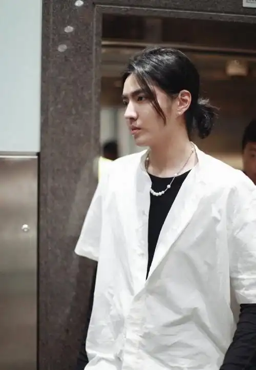 吴亦凡机场瘦回颜值巅峰,黑t白衬衫太日系,长发扎小辫炫酷帅气