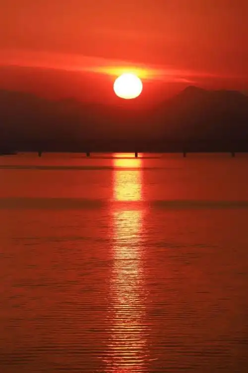 落日点缀城际,将天空尽数渲染,晚霞与水波相映,构成一幅璀璨的画卷.