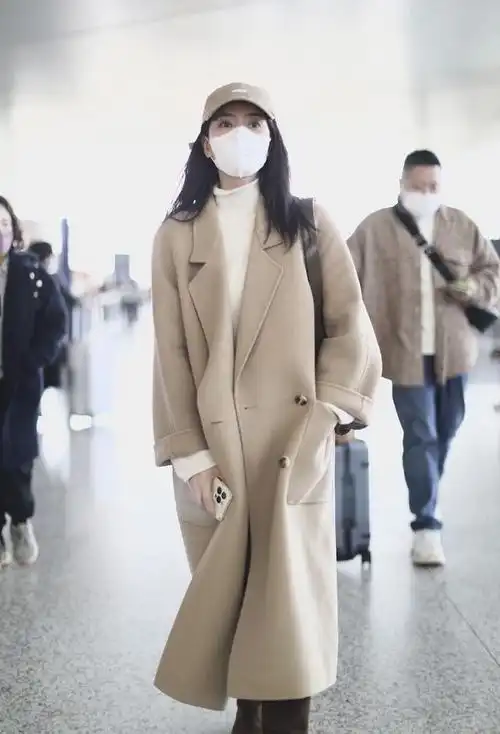 高圆圆现身机场,翻领羊绒大衣搭长筒靴,时尚优雅又显气质