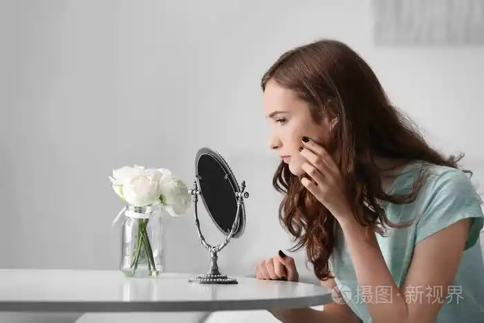 年轻漂亮的女孩在家照镜子