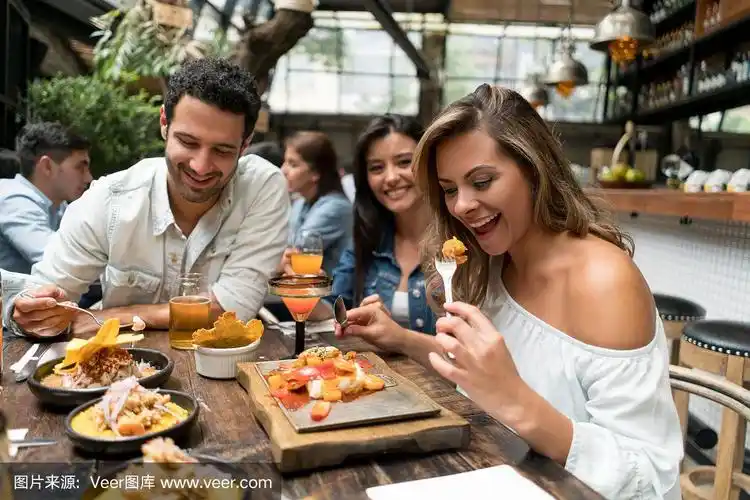 和一群朋友在餐馆吃饭的快乐女人