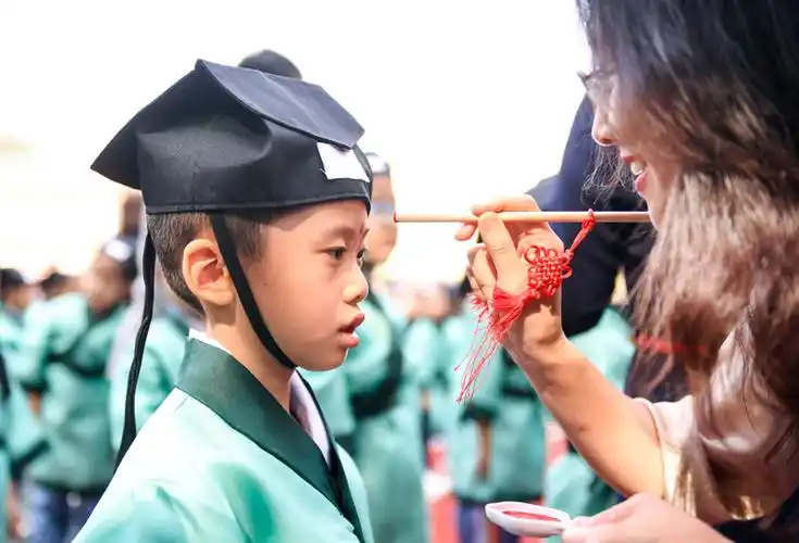 长春市朝阳区北安小学的老师在开笔礼仪式上为一年级新生点朱砂