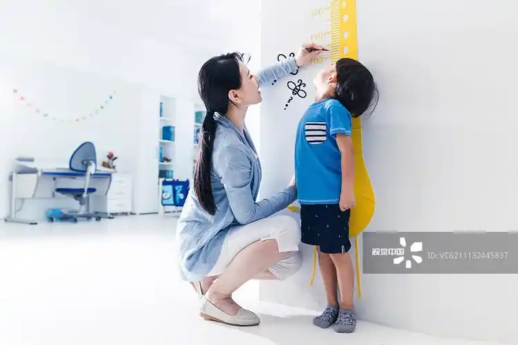 妈妈在为小男孩测量身高