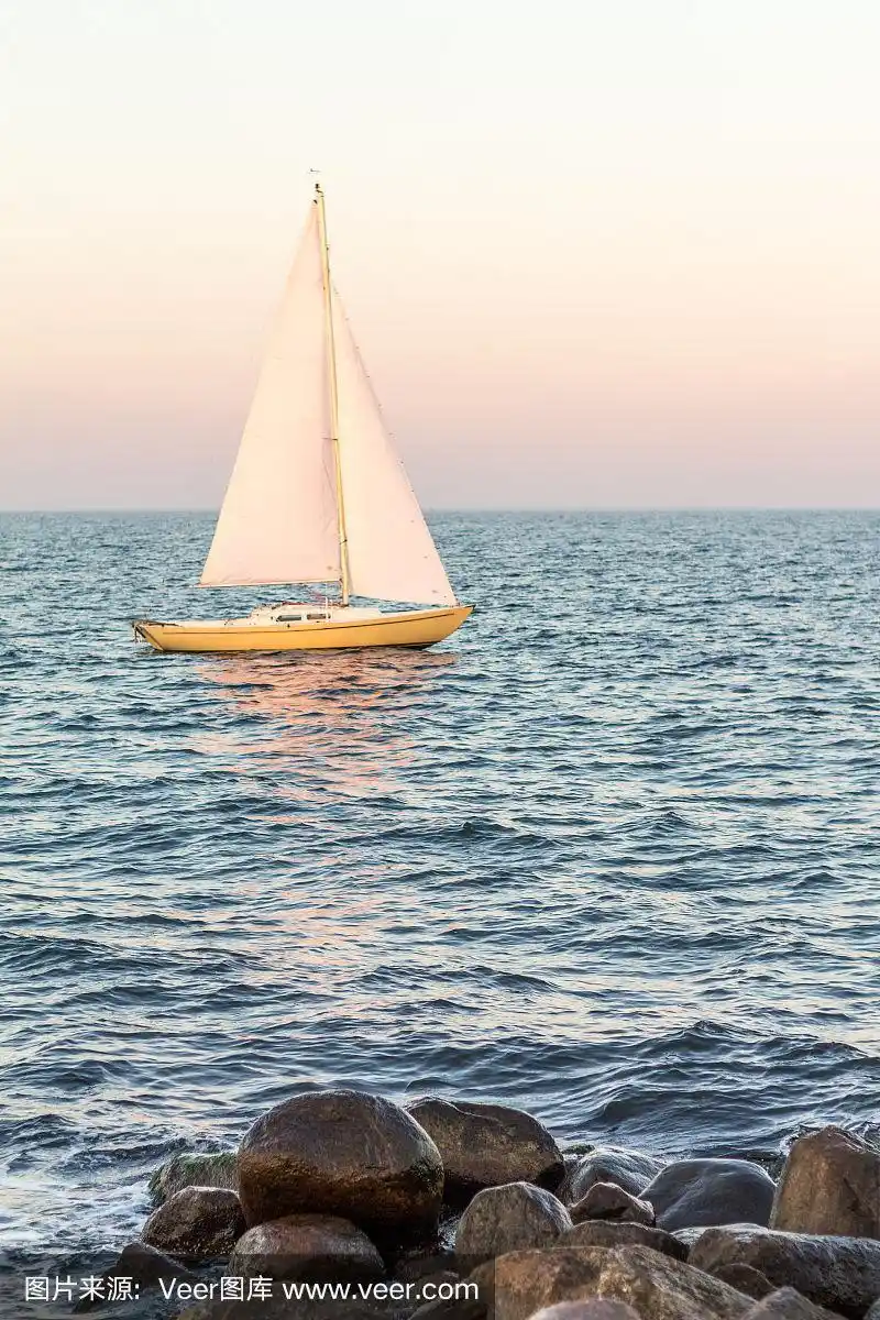 大海里的黄色帆船,前面是石头
