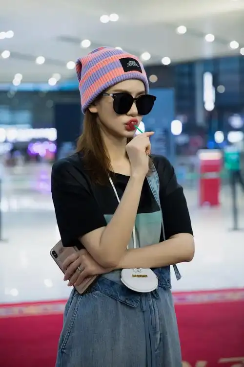 戚薇机场凹造型,大热天戴羊毛帽,吃起棒棒糖,俏皮又少女!