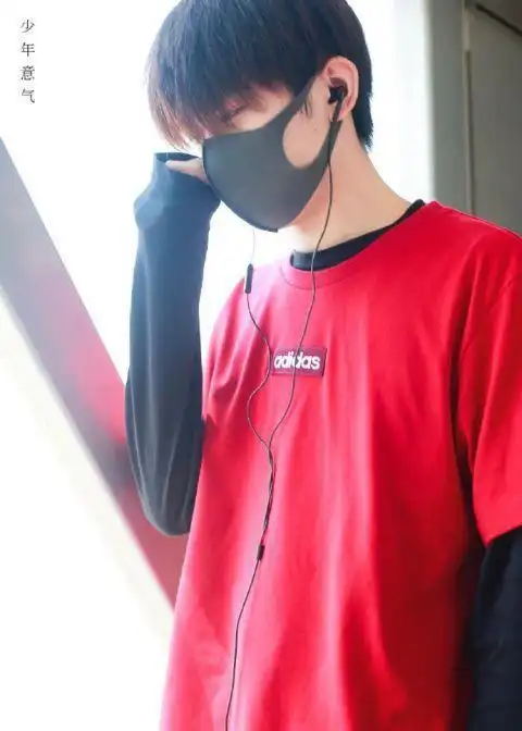易烊千玺红黑配现身机场刘海遮眼面带口罩尽显少年气