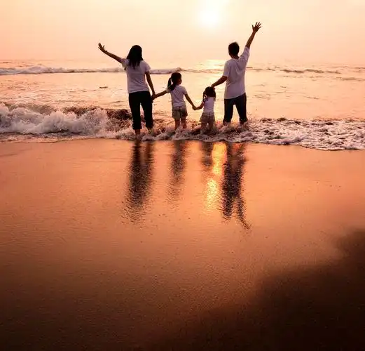 幸福的家庭牵手在沙滩上看日落幸福牵手